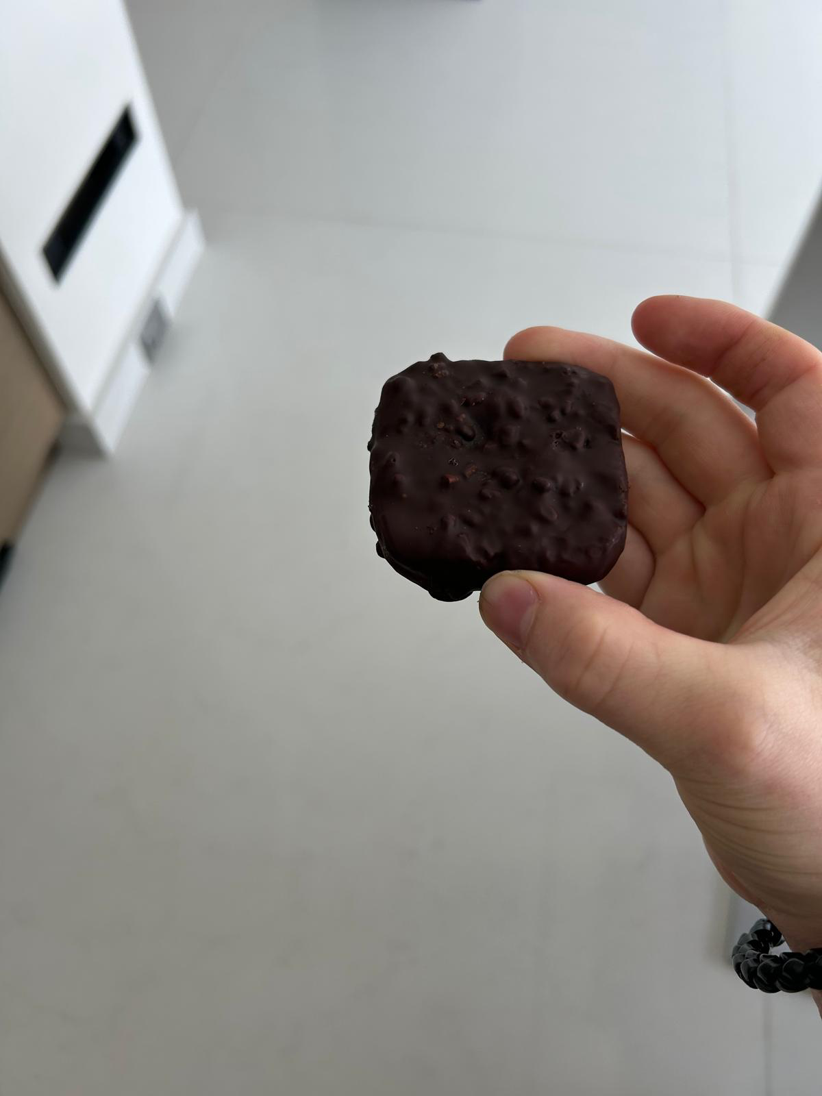 Actual square Gut Freak chocolate bar held in a hand